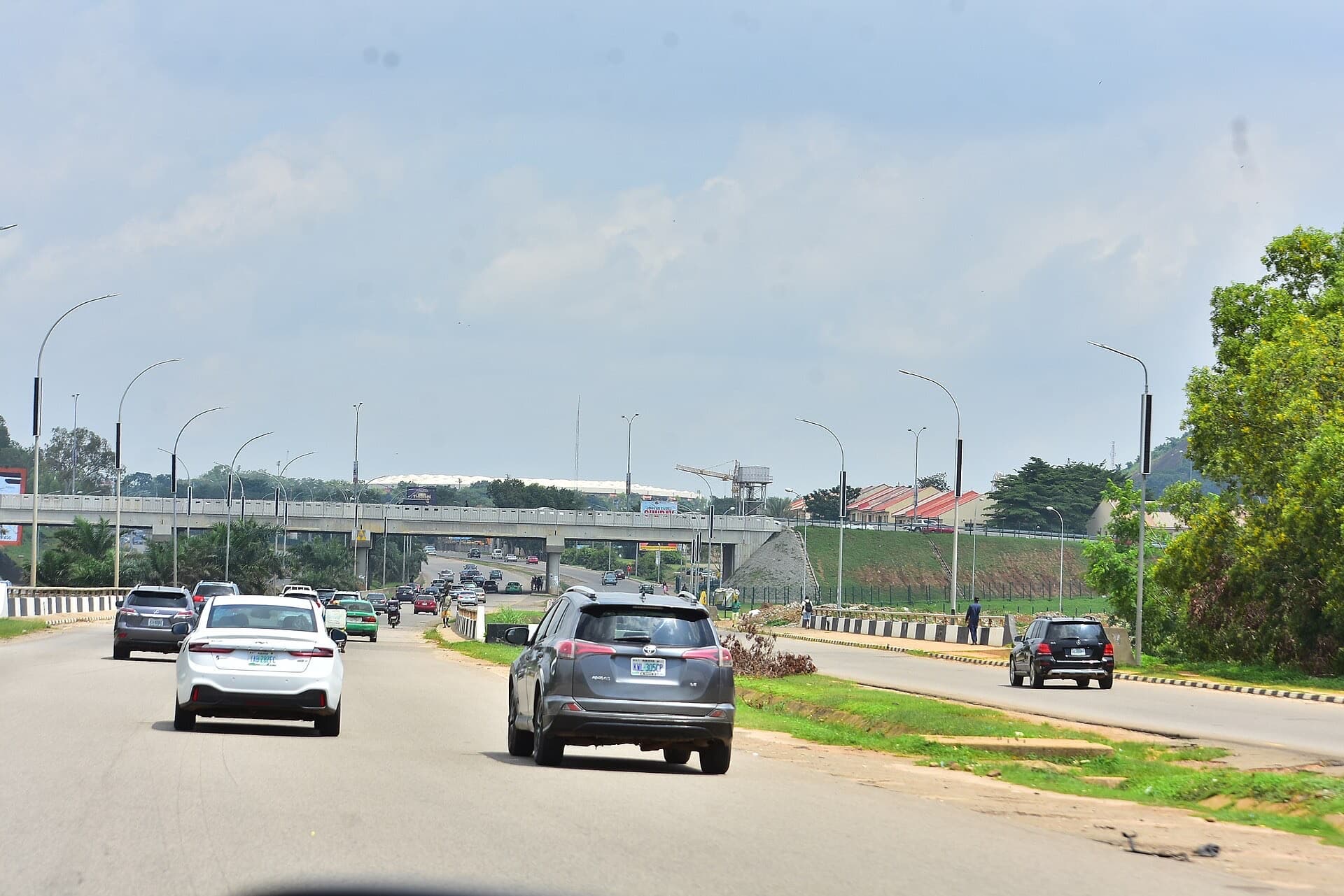 Traffic moving along an Abuja highway towards a flyover